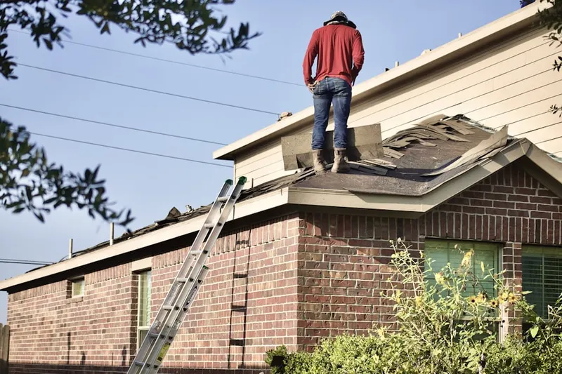 Professional roofer working on a residential roof in East Meadow